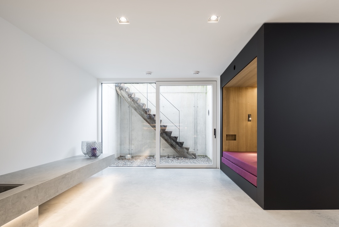 Moderner Wohnraum mit Sichtbeton und Treppe von Hengster Haustechnik